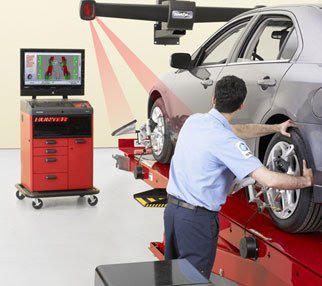 Técnico trabajando con un equipo de alineado de ruedas